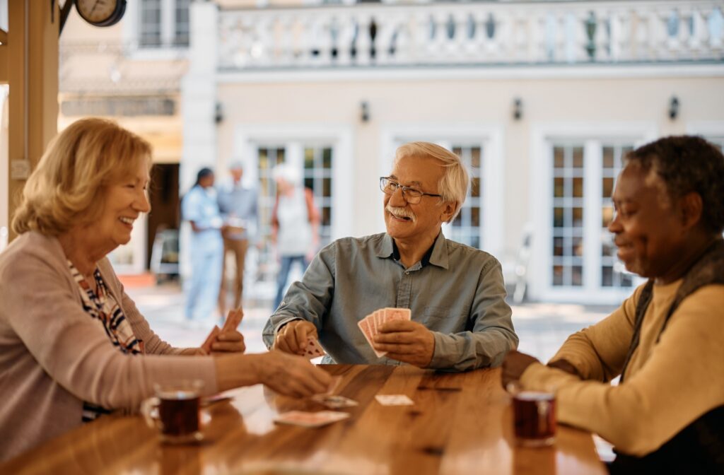 A group of older adults playing card games together in an independent living community.