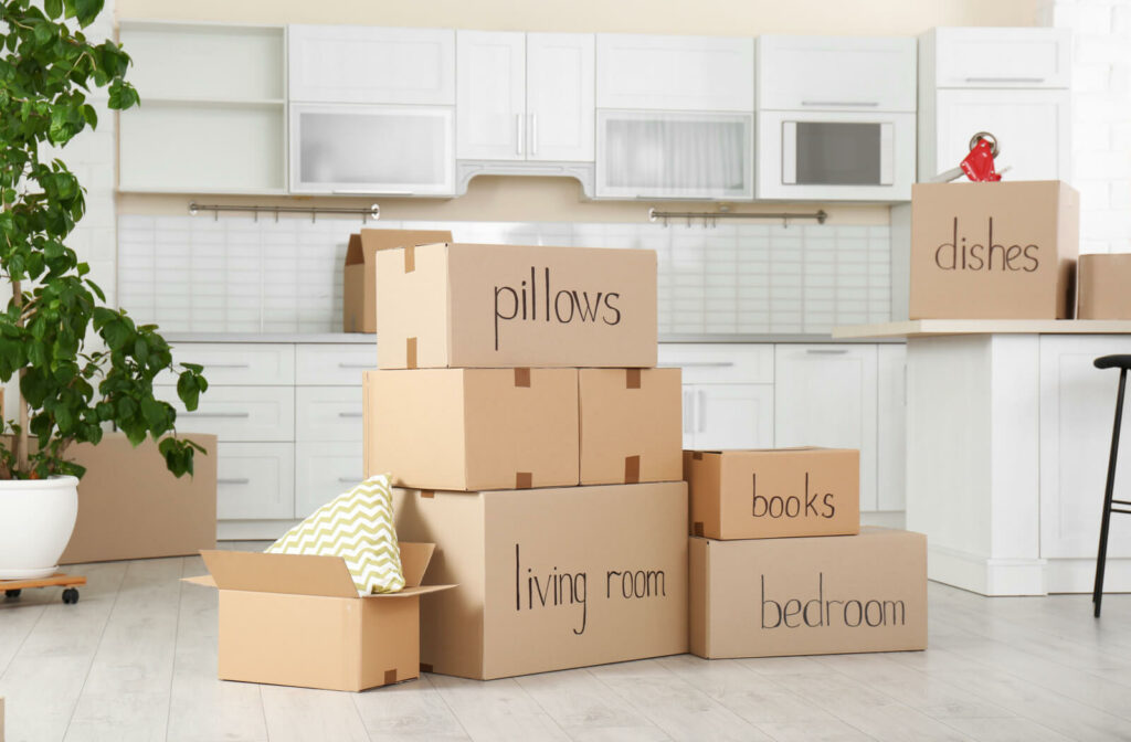 A stack of cardboard boxes labeled according to which room the contents will be placed.